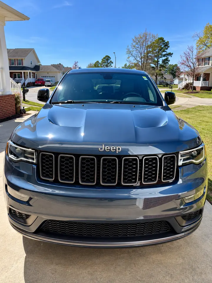 Front of a gray Jeep Grand Cherokee with a glossy hood and clear, coated windshield